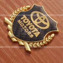 Эмблема Toyota с золотистым гербом