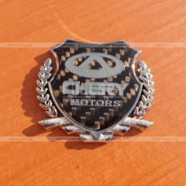 Значок герб на карбоновом фоне с эмблемой Chery