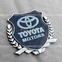 Эмблема Тойота на карбоновом фоне с хромированным гербом